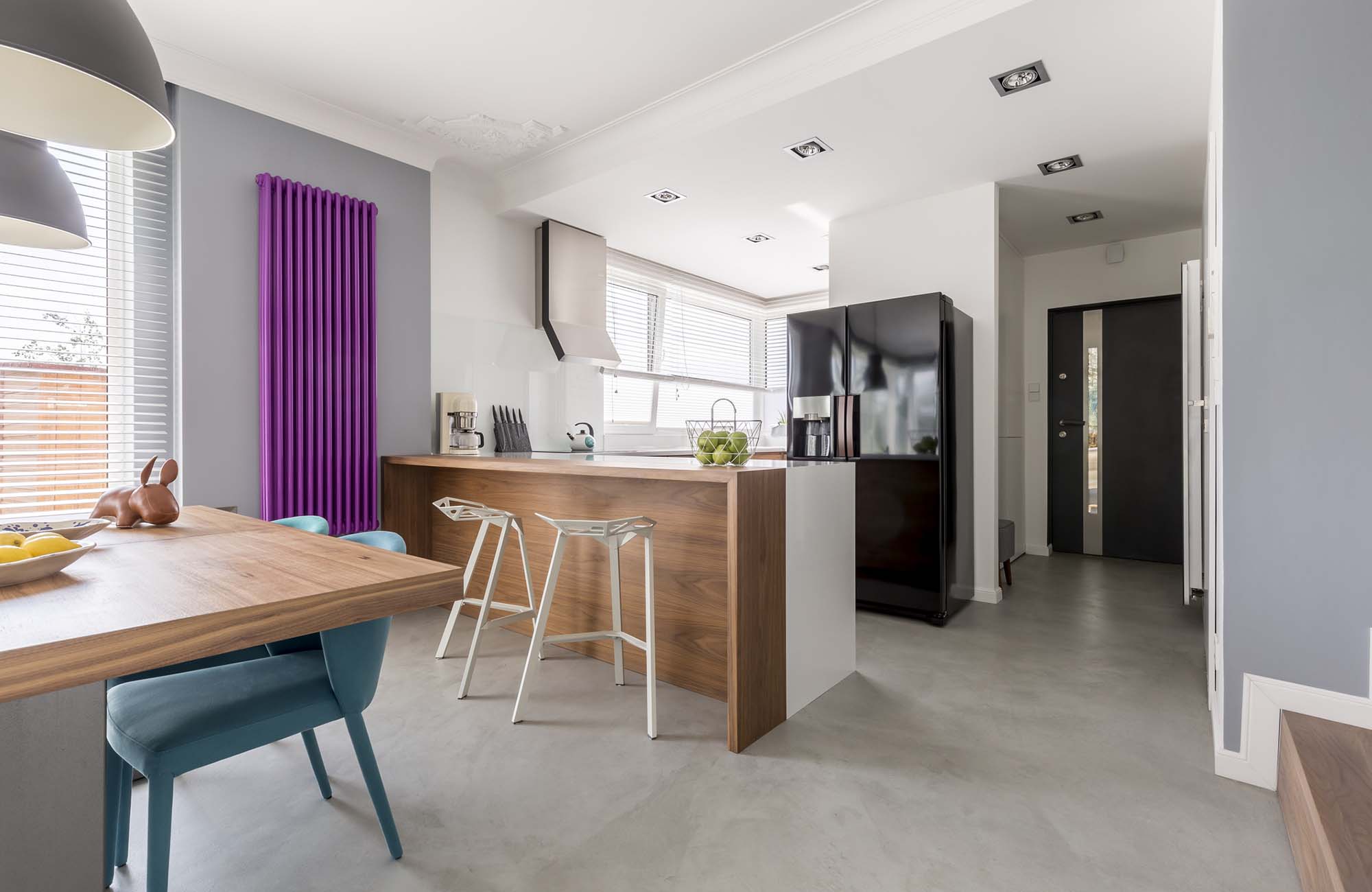 Dining room, kitchen and entrance in contemporary family house with minimalist gray design, colorful accents and wooden furniture