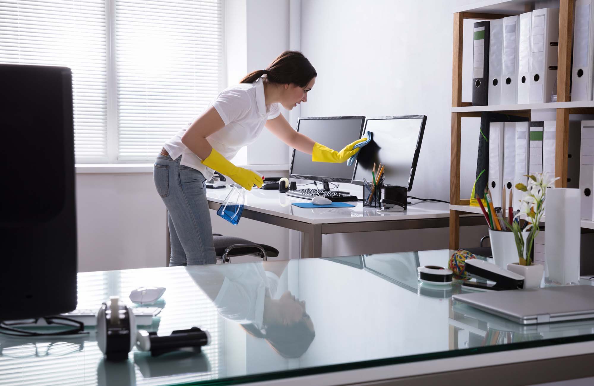 Woman Cleaning Computer In Office. Young Woman Cleaning Computer With Rag In Office